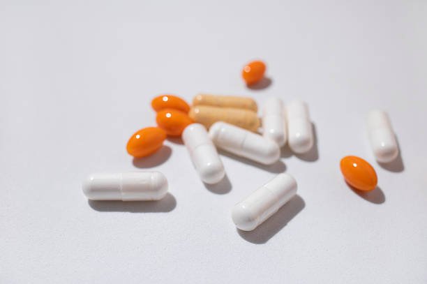 Different capsules vitamins, natural supplements, nutraceuticals on light gray background top view. Tablets, pills close up. Medical pharmaceutical background